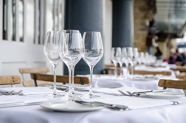 Empty table seen from side on terrace of restaurant Empty table seen from side on terrace of restaurant, during day of springtime. white restaurant dishes stock pictures, royalty-free photos & images