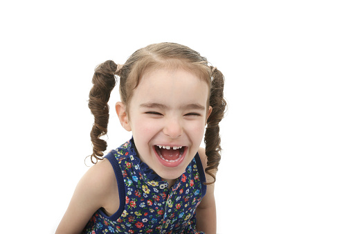 close up of cute little girl laughing on white background