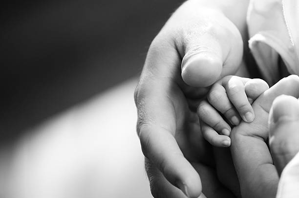 istock Baby hand gently holding adult finger 537818708
