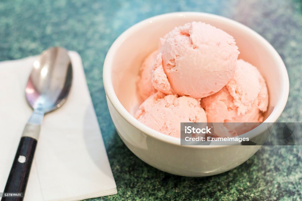 Homemade Strawberry Icecream Homemade pink strawberry icecream scooped into a bowl 2015 Stock Photo