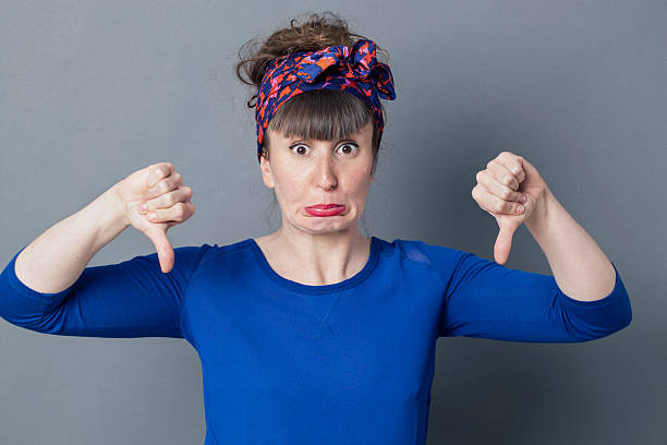 istock stunned young woman with thumbs down making a face 537819860