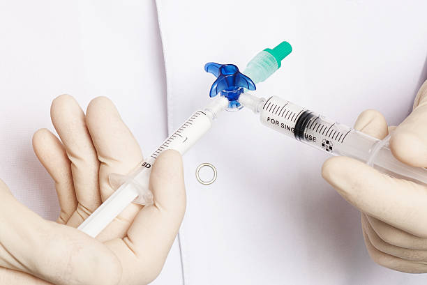 seringue dans la main du docteur - cold and flu vaccination injecting aids photos et images de collection