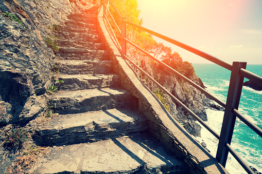 Stairways in rock over sea at sunset. The Way of Love Via dell'Amore in Cinque Terre, Italy