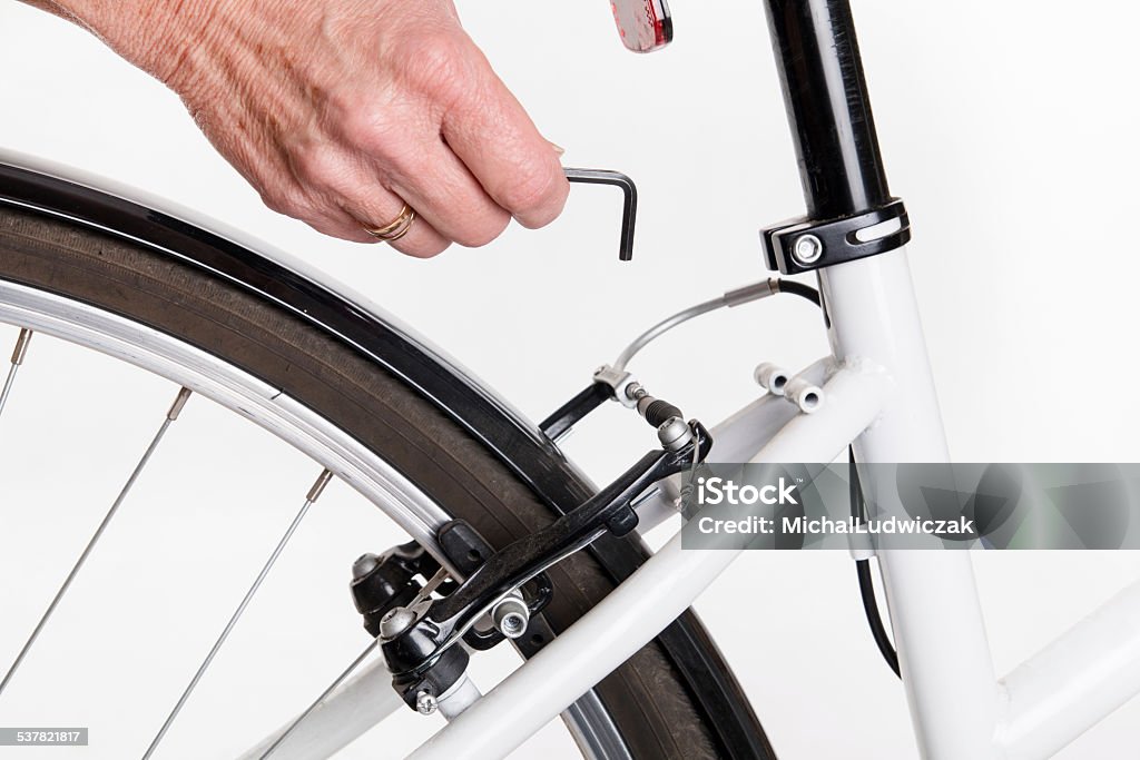 Adjustment and repair of the bike with the allen key Adjustment and repair of the bike with the allen key - studio shoot Hex Wrench Stock Photo