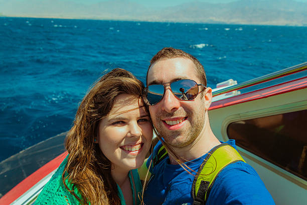 istock Happy couple sailing on a boat and taking selfie 537823840