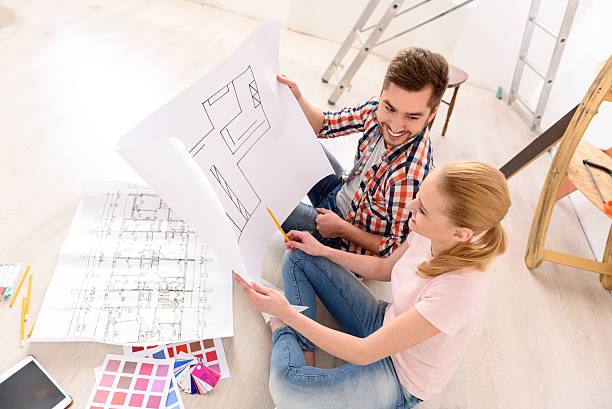 istock Cheerful couple looking at construction house plan 537824600