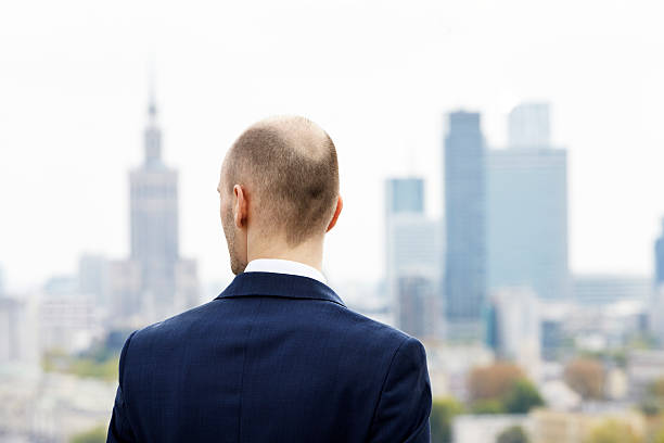 Looking at downtown Businessman standing on the roof and looking at downtown business person one man only blue standing stock pictures, royalty-free photos & images