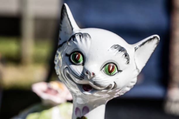 closeup of smiling old ceramic cat for collectors and collection at garage sale of flea market, outdoors