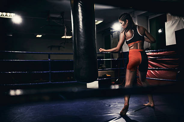 istock Female boxer training with a punching bag 537832792