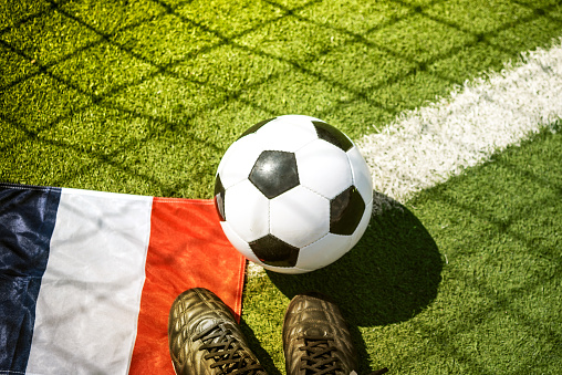 soccer ball on field  with french flag and soccer shoes
