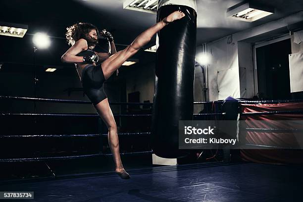 Female Kickboxer Training With A Punching Bag Stock Photo - Download Image Now - Kickboxing, Women, One Woman Only