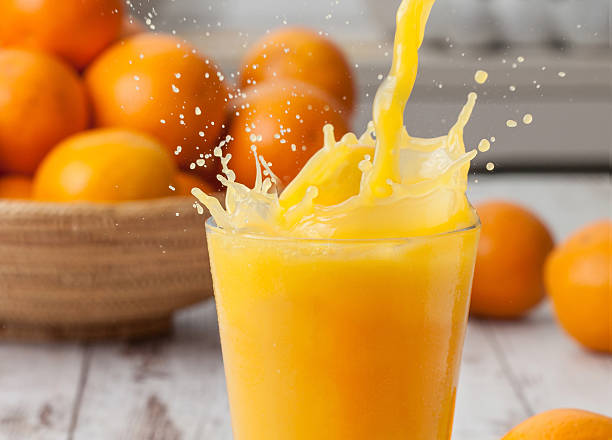 Orange juice splash Pouring a glass of orange juice creating splash orange juice stock pictures, royalty-free photos & images
