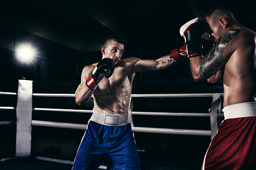 Photo of two boxers fighting in a boxing ring.