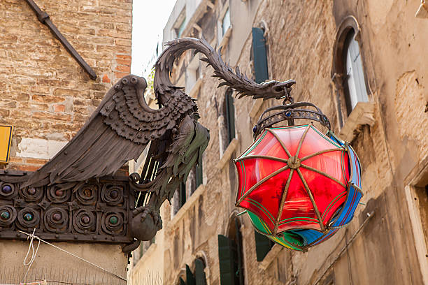 Barcelona, Spain - September 19, 2022: A large Chinese dragon holding a bamboo lantern on the corner of Casa Bruno Cuadros facade.  An umbrella is attached to the building's balcony below the dragon, and no people are in the scene.