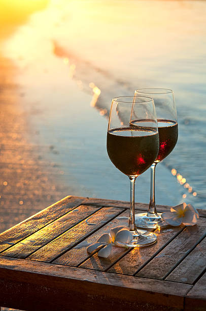 istock Romantic beach scene: two glasses of red wine at sunset 537840238