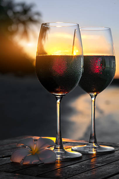 istock Romantic beach scene: two glasses of red wine at sunset 537840466