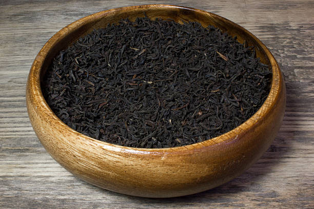 istock Dry tea leaves for black tea on wooden background 537841794