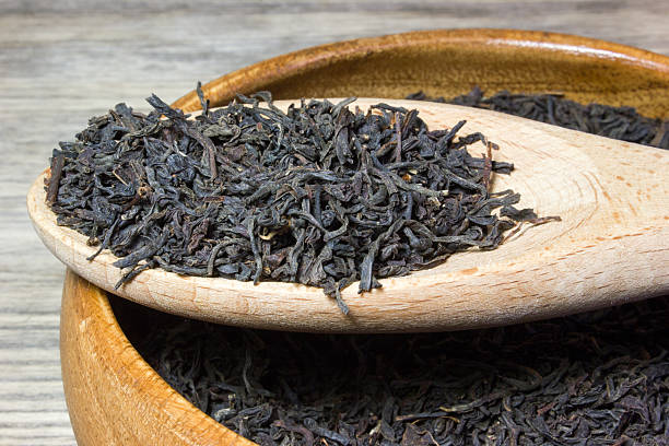 istock Dry tea leaves for black tea on wooden background 537841926