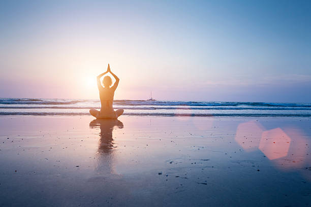 donna praticare yoga sulla spiaggia - equanimity foto e immagini stock