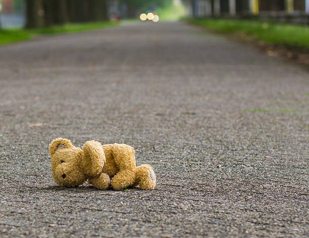 teddybär liegt auf der straße - desorientiert stock-fotos und bilder