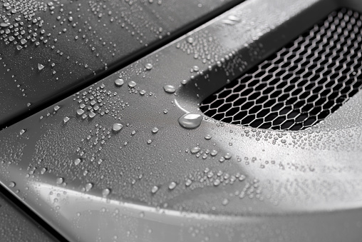 Closeup of droplets on grey car trunk