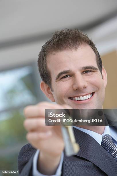 Real Estate Agent Holding Out House Key Stock Photo - Download Image Now - 2015, Adult, Apartment