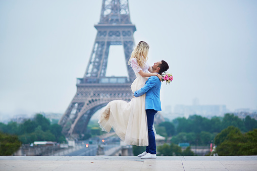 Just married couple in Paris, France. Beautiful young bride and groom near the Eiffel tower. Romantic wedding in Paris concept