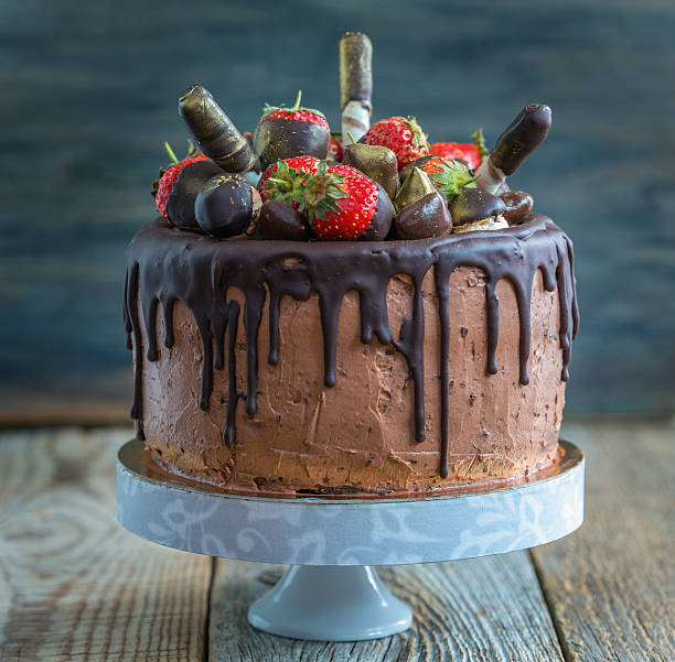 istock Chocolate cake with strawberries, wafer rolls and candies. 537868468