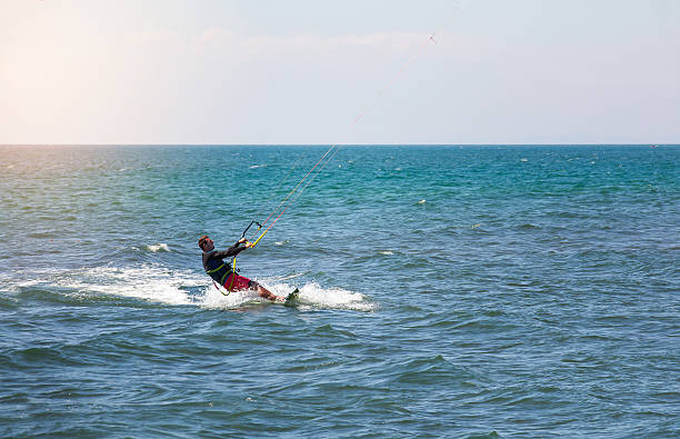 istock Athletic man riding on kite surf board 537869592