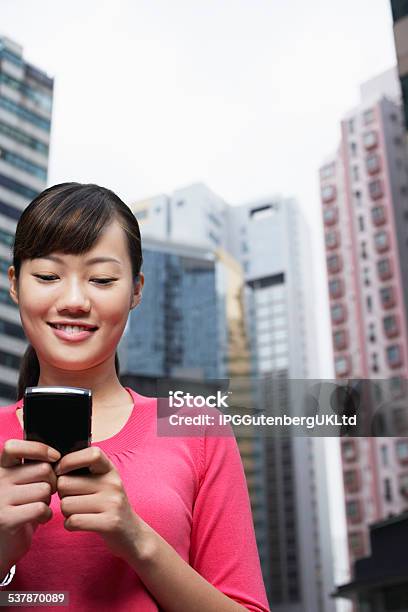 Businesswoman Reading Text Message On Cell Phone Stock Photo - Download Image Now - 2015, Adult, Architecture