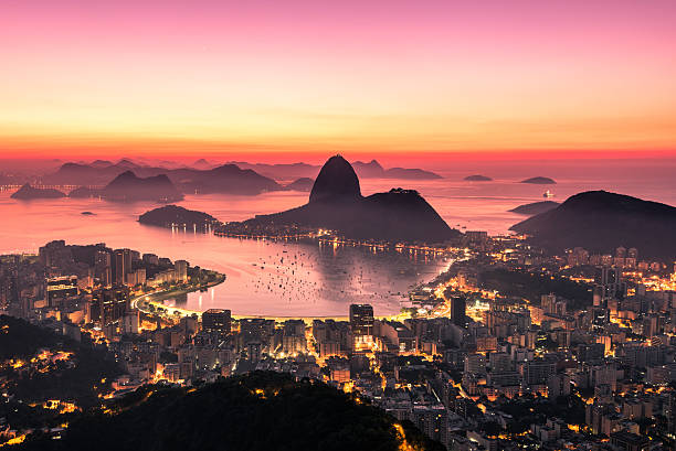 Rio de Janeiro by Sunrise Rio de Janeiro just before Sunrise, City Lights, and Sugarloaf Mountain. natural landmark photos stock pictures, royalty-free photos & images