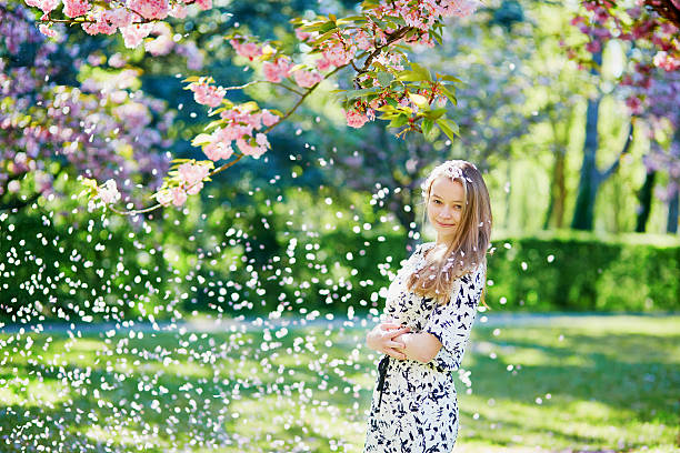 istock Beautiful young woman in blooming spring park 537872152