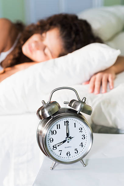 istock Young woman in bed, alarm clock on nightstand 537872187
