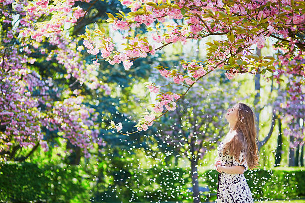 istock Beautiful young woman in blooming spring park 537872342