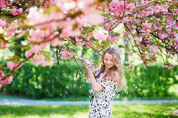 istock Beautiful young woman in blooming spring park 537872710