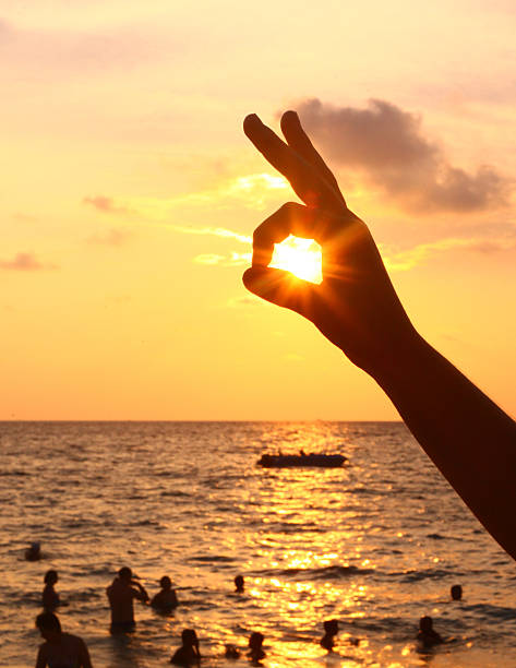 atardecer en la playa y con un ojo sol dedo liebre - women sign love trap fotografías e imágenes de stock