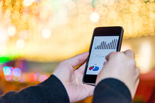 istock holding a smart phone with business chart 537872947