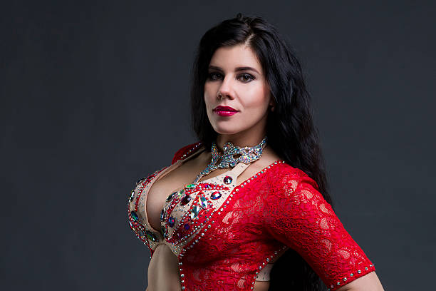 istock Young exotic eastern women in red dress on gray background 537873190