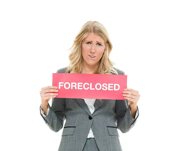 Photo of Businesswoman holding foreclosed sign