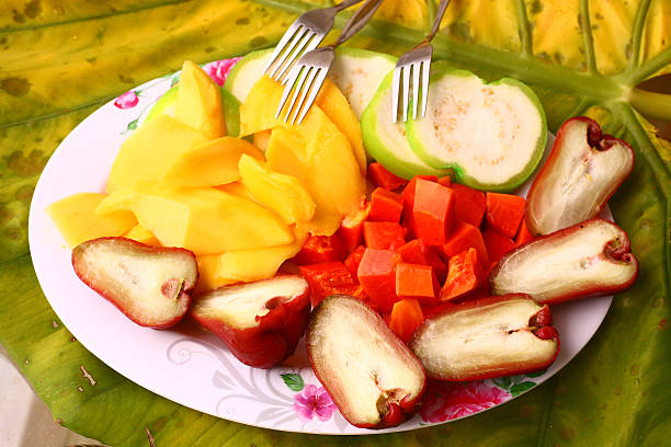 istock mango, papaya, corambola guava slived on the plate 537873890