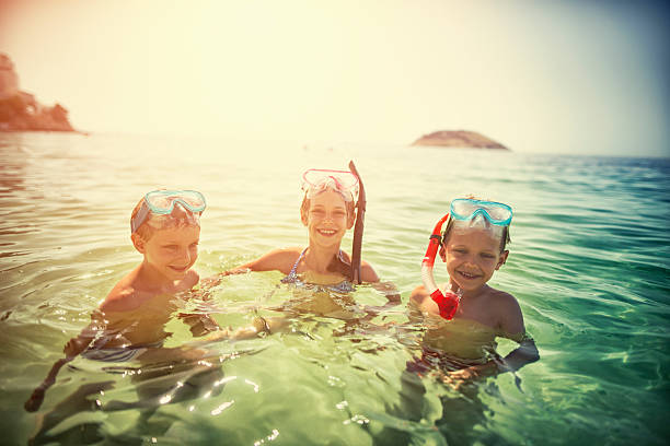 istock Kids having fun snorkeling in beautiful sea 537875942
