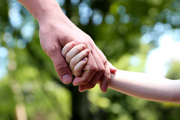 istock Father holds the hand of a small child 537875984