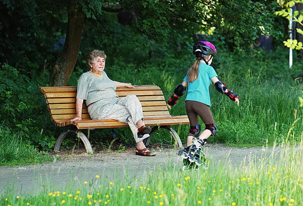 grandma on park bench looking at granddaughter
