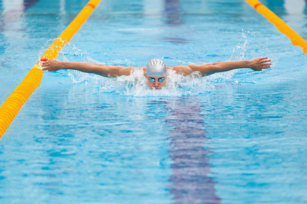 istock dynamic and fit swimmer in cap breathing performing the butterfly 537878884