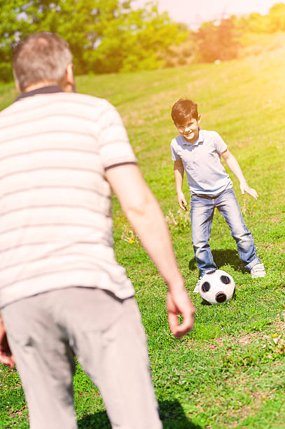 istock Cheerful old man and grandson entertaining in park 537879220