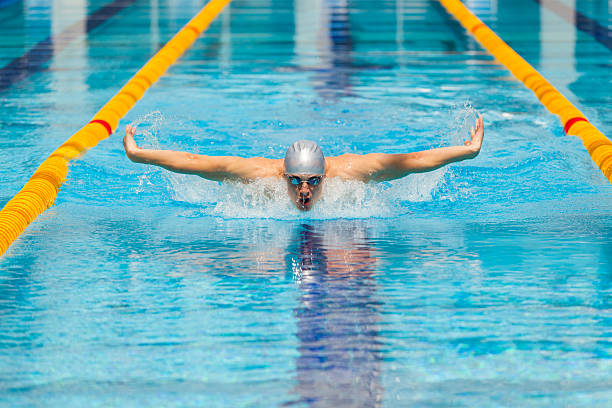 istock dynamic and fit swimmer in cap breathing performing the butterfly 537880284