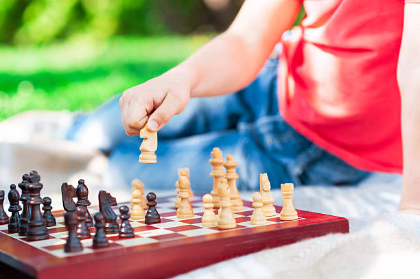 istock Clever male child is playing chess outdoors 537880558