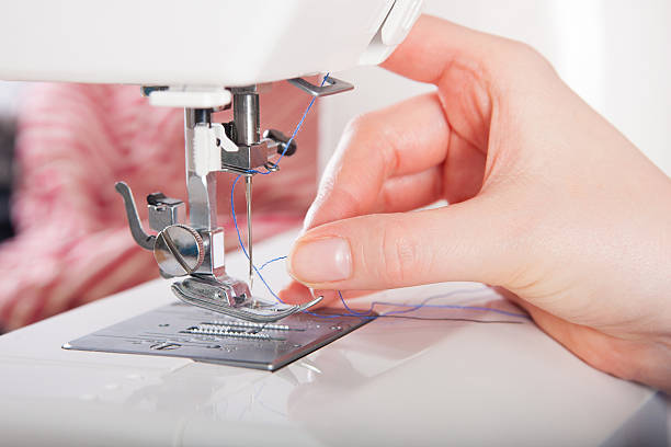 donna sulla macchina da cucire threading (epilazione a filo) - sewing women tailor teenage girls foto e immagini stock