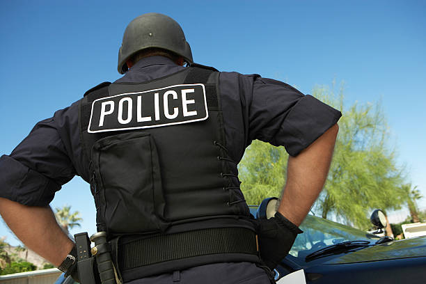 istock Policeman In Uniform Standing Against Car 537889023