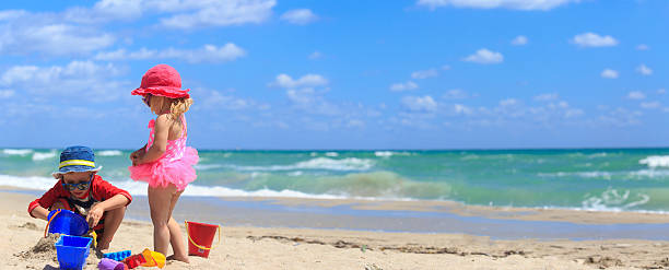 istock kids play with sand on summer beach 537890602